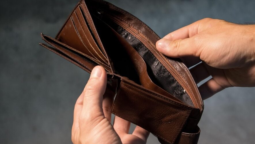 Man holding open an empty brown wallet