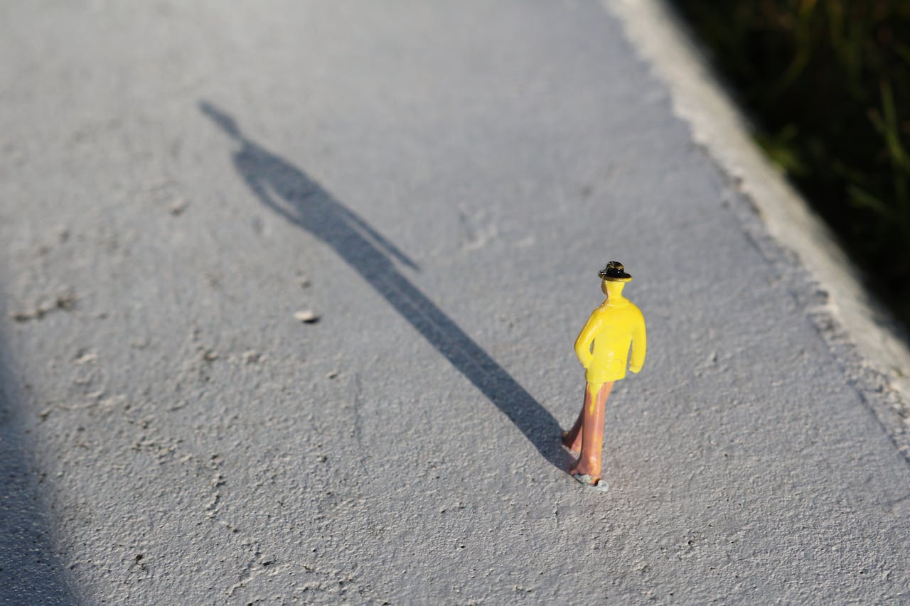 small figure of a man in yellow zoomed in on the pavement