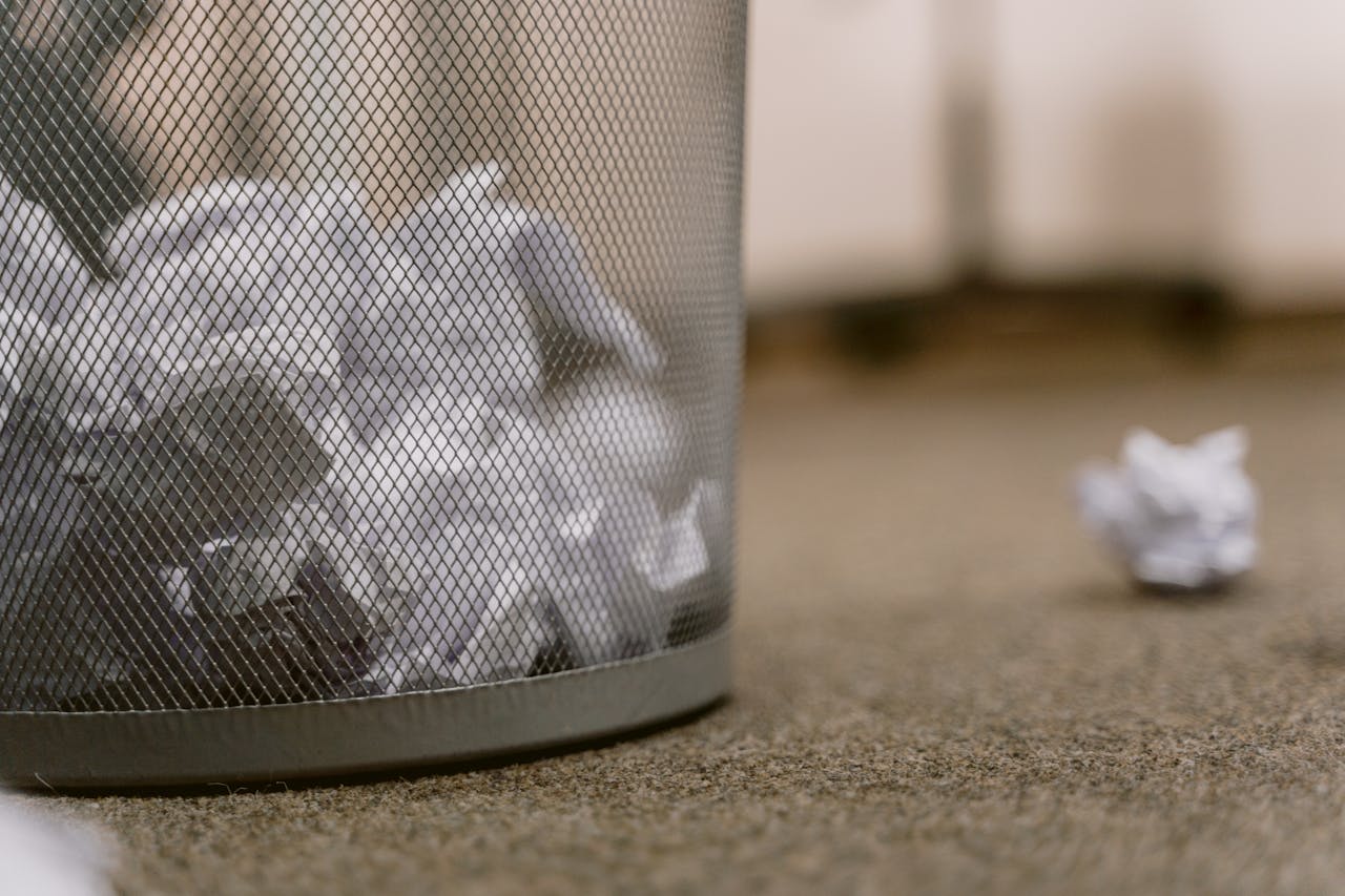 an office trash can with paper