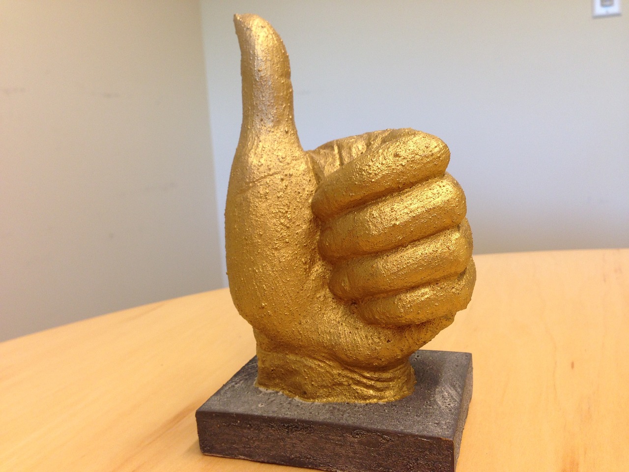 a golden thumbs up statue on desk