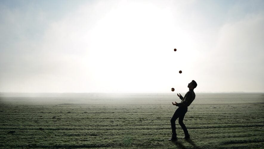 men juggling on a plain, black and grey