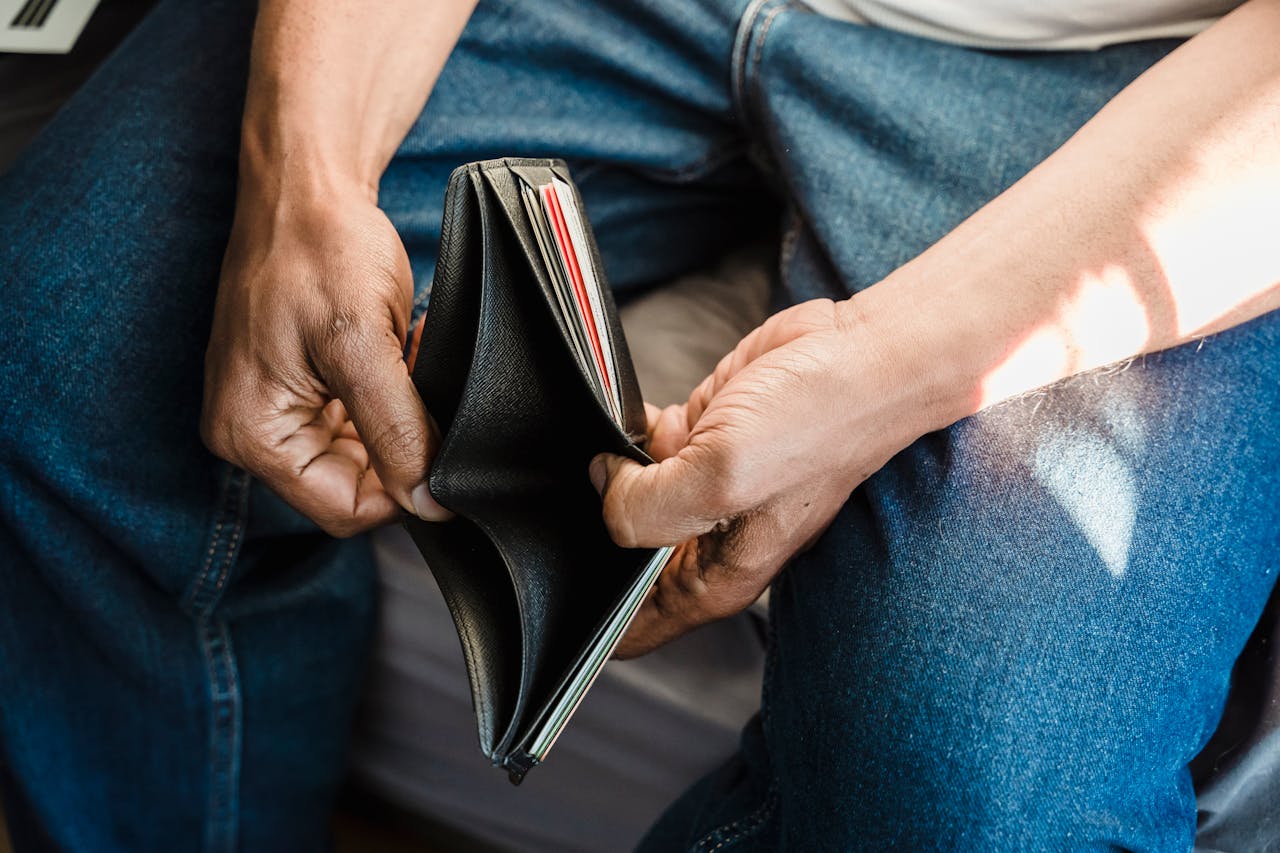 guy holding open a wallet with no money in it