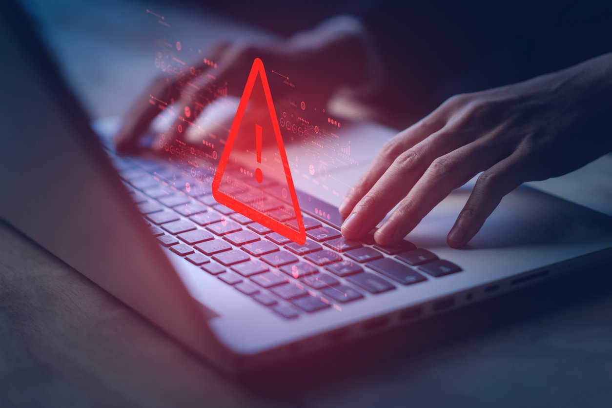 red warning symbol over a laptop keyboard